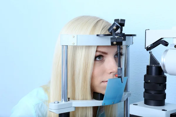 Optometry concept - pretty young woman having her eyes examined by eye doctor — Stock Photo, Image