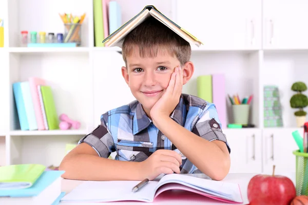 Schoolboy sitting at table in classroom — Stock Photo, Image