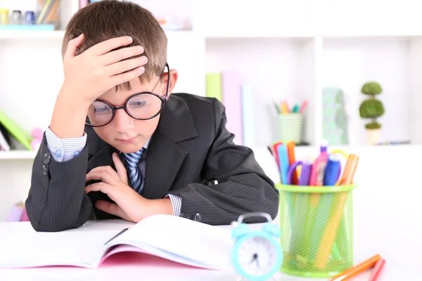 Schoolboy sitting at table in classroom — Stock Photo, Image