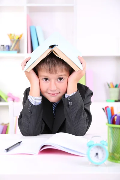 Schooljongen zitten aan tafel in klas — Stockfoto