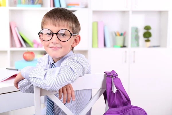 Skolpojke sitter vid bord i klassrummet — Stockfoto