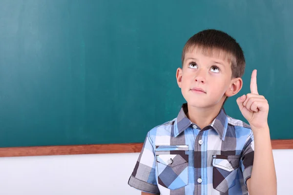 Schoolboy at blackboard in classroom — Stock Photo, Image