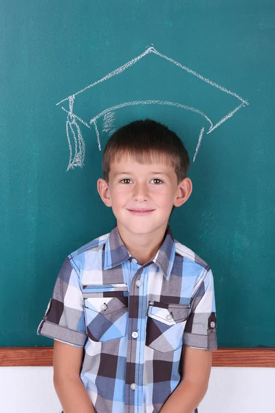 Schoolboy at blackboard in classroom — Stock Photo, Image