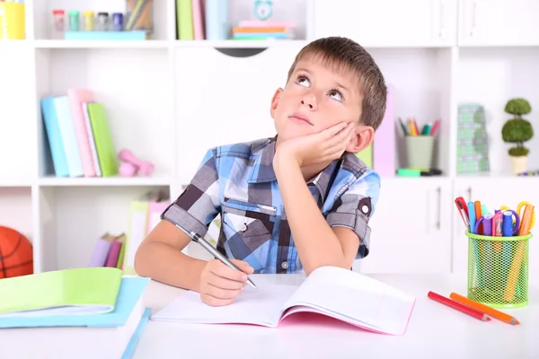 Schoolboy sitting at table in classroom — Stock Photo, Image