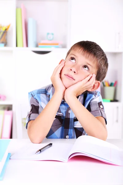 Schoolboy sitting at table in classroom — Stock Photo, Image