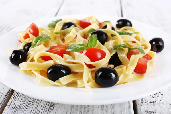 Spaghetti with tomatoes, olives and basil leaves — Stock Photo, Image