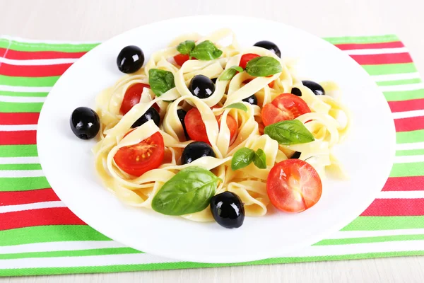 Спагетті з помідорами, оливками та листям базиліка — стокове фото