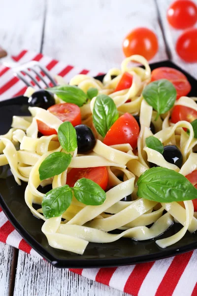 Špagety s rajčaty, olivami a bazalkou listy — Stock fotografie