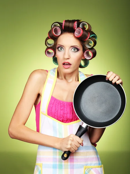 Hermosa chica en rulos de pelo sobre fondo verde — Foto de Stock