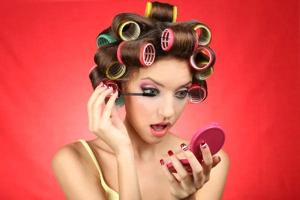 Hermosa chica en rulos de pelo sobre fondo rojo —  Fotos de Stock