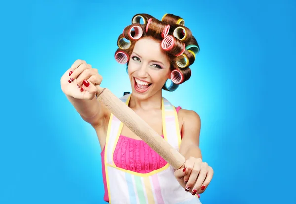 Krásná dívka v natáčky na vlasy na modrém pozadí — Stock fotografie