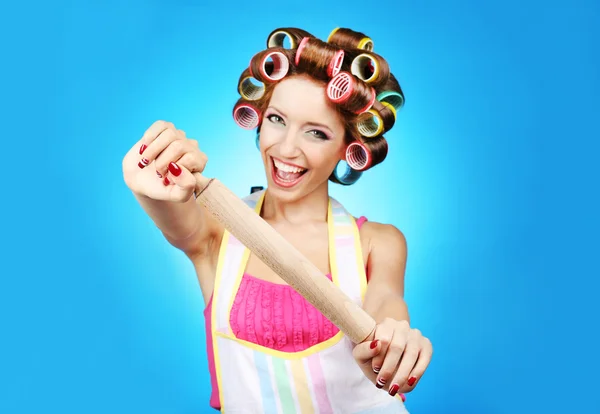 Hermosa chica en rulos de pelo sobre fondo azul — Foto de Stock