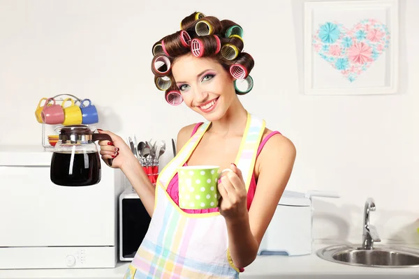 Bella ragazza in bigodini per capelli in cucina — Foto Stock