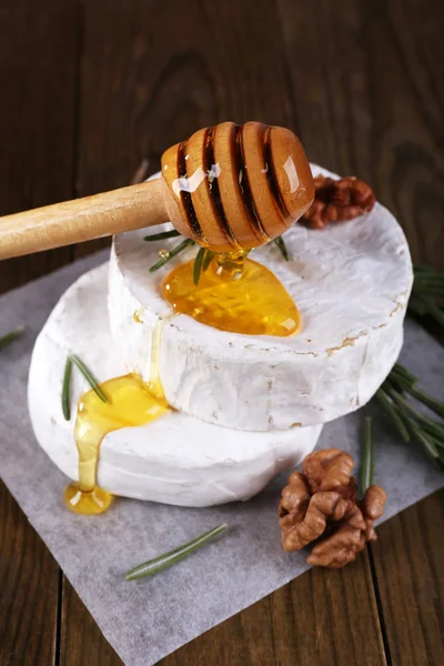Camembert formaggio, miele e noci su tovagliolo su sfondo di legno — Foto Stock