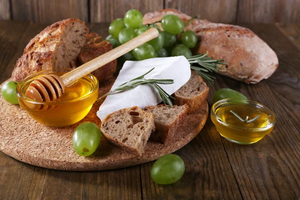 Queijo de camembert, pão, mel e uvas — Fotografia de Stock