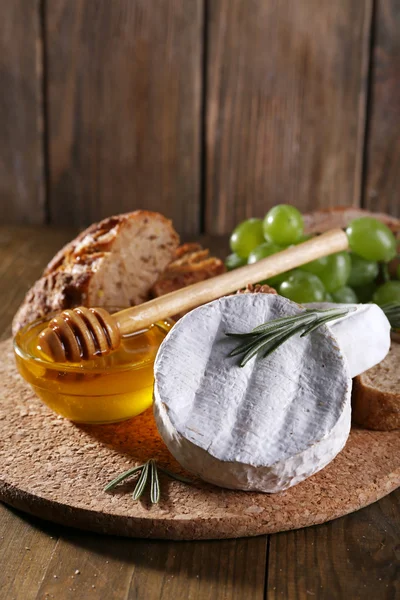 Queijo de camembert, pão, mel e uvas — Fotografia de Stock