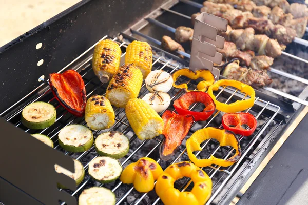 Skewers and vegetables on barbecue — Stock Photo, Image