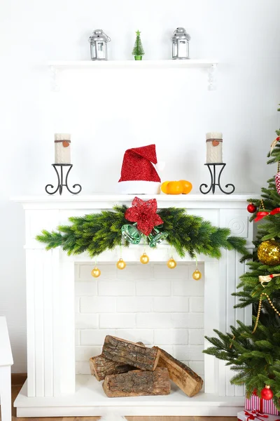 Kerstboom in de buurt van open haard in kamer — Stockfoto