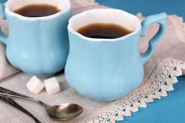 Cups of coffee with sugar and napkin on wooden table — Stock Photo, Image