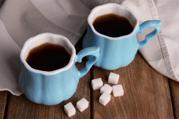 Tazas de café con azúcar y servilleta sobre mesa de madera — Foto de Stock