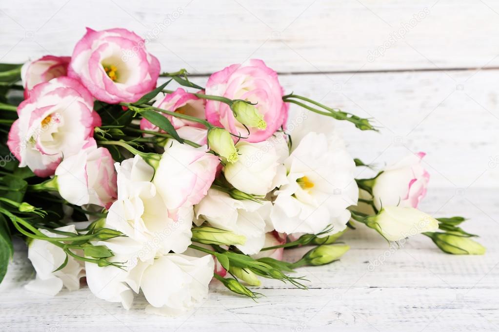 Beautiful eustoma flowers on wooden background