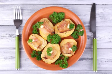 fırında patates tabakta ahşap zemin üzerine pastırma ile