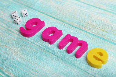 Ahşap arka plan üzerinde renkli harflerle oyun kelime oluşan