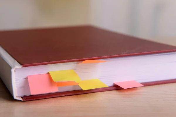 Livro com marcadores na mesa sobre fundo brilhante — Fotografia de Stock