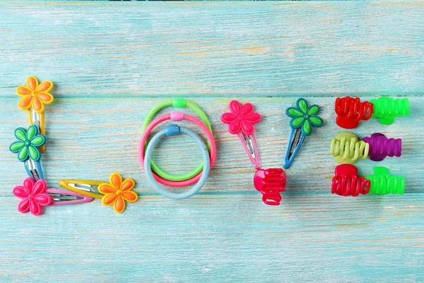 Love word formed with colorful scrunchies on wooden background — Stock Photo, Image