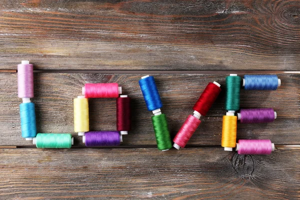 Palabra de amor formada con hilos de colores sobre fondo de madera —  Fotos de Stock