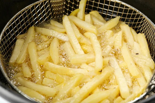 Batatas fritas em fritadeira, close-up — Fotografia de Stock
