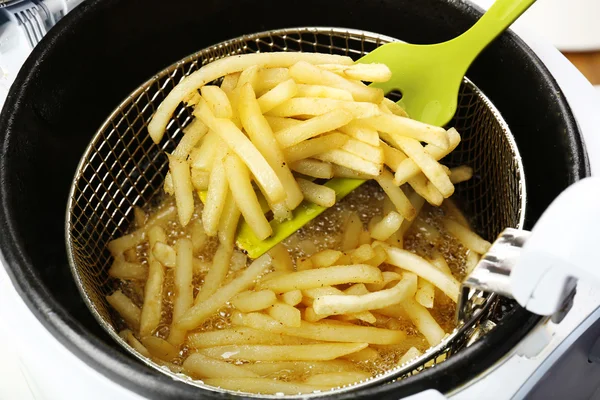 Franse frietjes in friteuse, close-up — Stockfoto