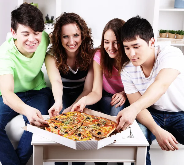 Jonge vrienden eten van pizza — Stockfoto