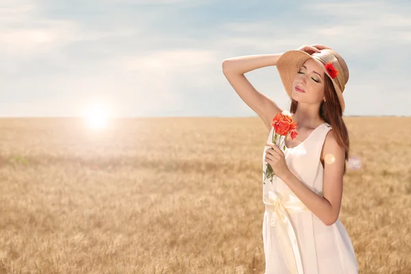 Portret van mooie jonge vrouw in veld — Stockfoto