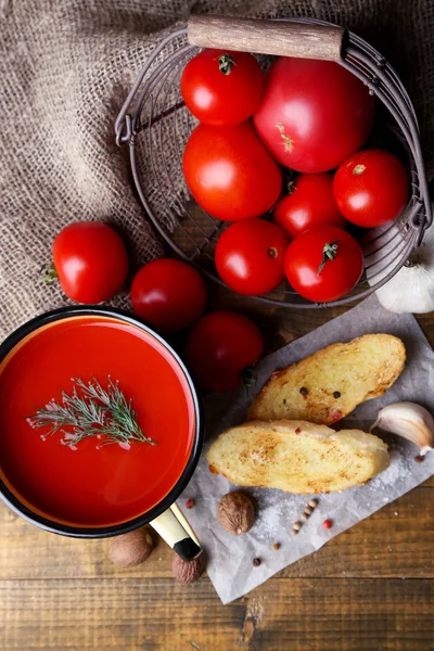 Homemade tomato juice in color mug, toasts and fresh tomatoes on wooden background — Stock Photo, Image