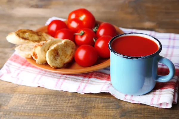 Zelfgemaakte tomatensap in kleur mok, toast en verse tomaten op houten achtergrond — Stockfoto