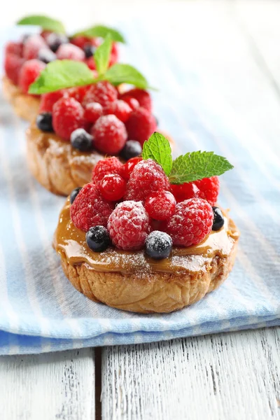 Süße Kuchen mit Beeren auf dem Tisch in Großaufnahme — Stockfoto