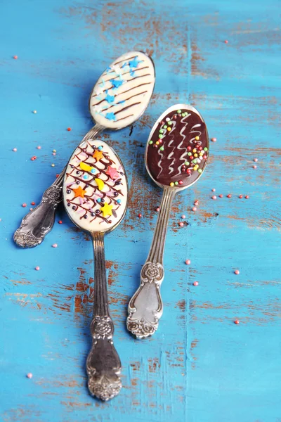 Löffel mit leckerer Schokolade zum Feiern auf altem blauen Holztisch — Stockfoto