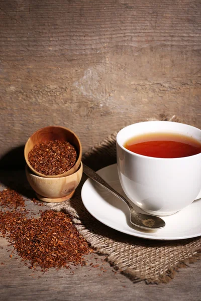 Cup of tasty rooibos tea, on wooden table — Stock Photo, Image