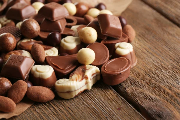 Different kinds of chocolates on wooden table close-up — Stock Photo, Image