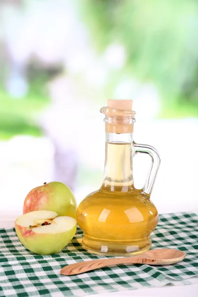 Cuka sari apel dalam botol kaca dan apel matang segar, di atas meja kayu, di latar belakang alam — Stok Foto