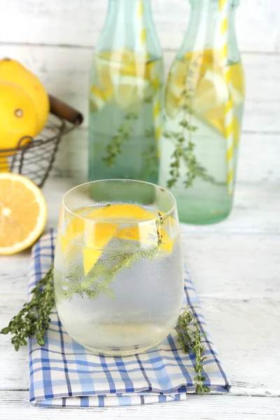 Tasty cool beverage with lemon and thyme, on wooden background — Stock Photo, Image