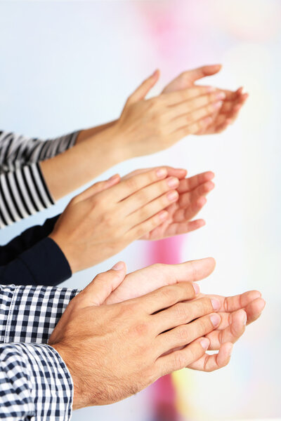 Clapping hands on bright background