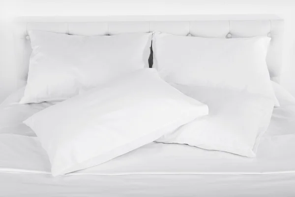 Белые подушки на кровати — стоковое фото