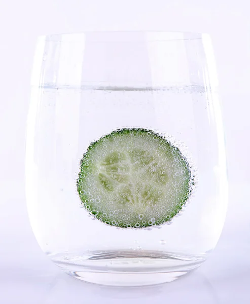 Pepino en vaso de agua aislado sobre blanco —  Fotos de Stock