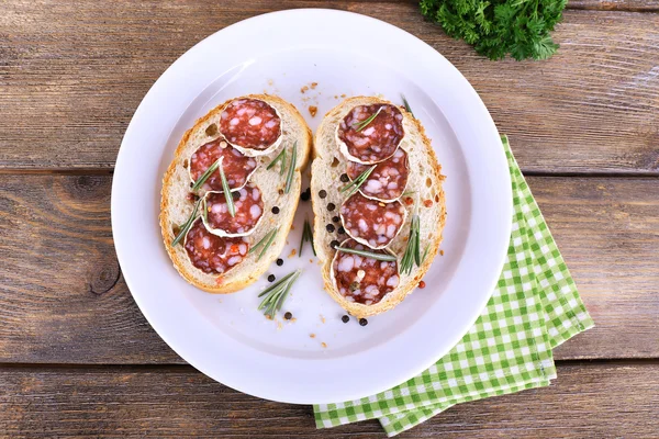 Sandwiches with salami on plate — Stock Photo, Image