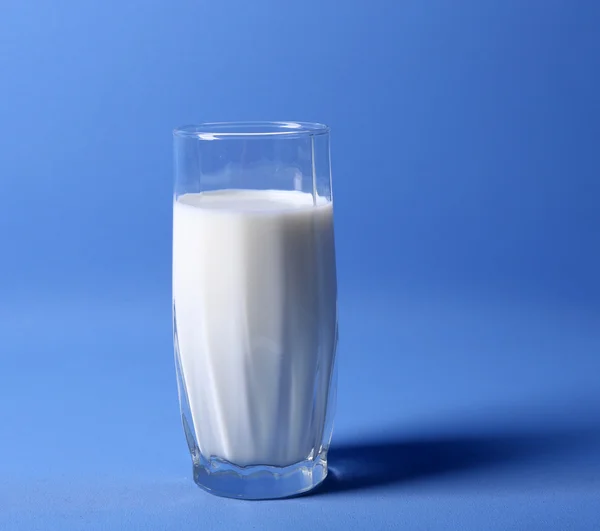 Milch im Glas auf Blau — Stockfoto