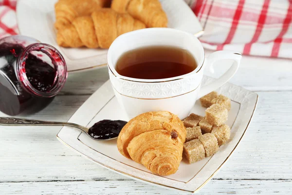 Petit déjeuner avec thé, confiture et croissants frais — Photo