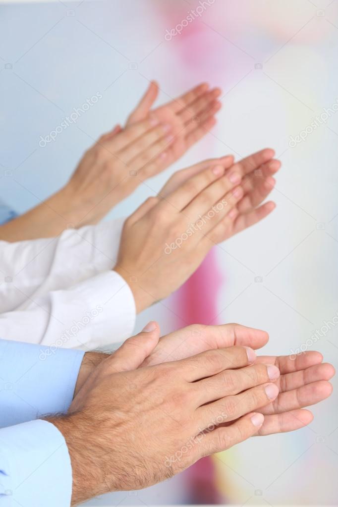 Clapping hands on bright background