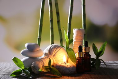 Bitkisel masaj çanta, mum ve bambu doğal zemin üzerine masada Spa kompozisyonu